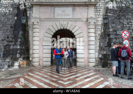 Montenegro, 30 Aprile 2019: gruppo di turisti che arrivano al di fuori della città vecchia di Kotor attraverso l'antica porta della città Foto Stock