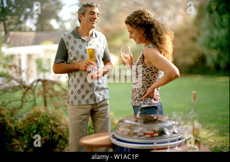 Un paio di condividere momenti piacevoli sorseggiando un drink in giardino. Foto Stock