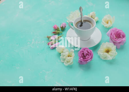 Mattina tazza di caffè fresco e di un bel colore rosa e bianco rose fiori ,disposizione piatta, spazio copia.bevanda caffè concetto con tazza di americano e le rose Foto Stock