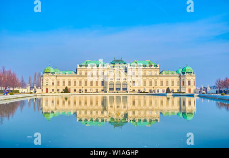 VIENNA, Austria - 18 febbraio 2019: la facciata del Belvedere Superiore palazzo in stile barocco e la sua riflessione sulla superficie della grande piscina in fron Foto Stock