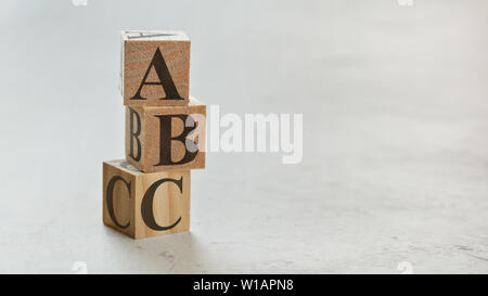 Palo con tre cubi di legno - lettere ABC su di essi, spazio per più di testo / immagini sul lato destro. Foto Stock