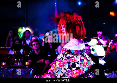 La ballerina vestita in kimono floreali e parrucca rosso di eseguire presso il ristorante del robot, Tokyo, Giappone Foto Stock