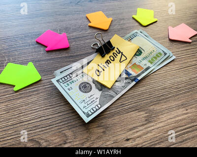 Pagamenti alimony. Pila di dollari con firmare assegni alimentari e denaro. Il divorzio e il concetto di separazione Foto Stock