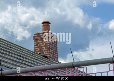 ​Chimney Pot, Camino al di sopra di un nuovo tetto, su un ri-costruire, ridondante fattoria, la conversione. Lunga e breve di muratura. Piastrelle ancora di essere poste sul tetto. Foto Stock