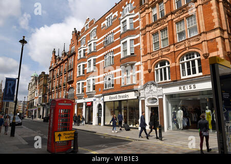 Telefono rosso box e negozi su Long Acre in Covent Garden Londra Inghilterra Foto Stock