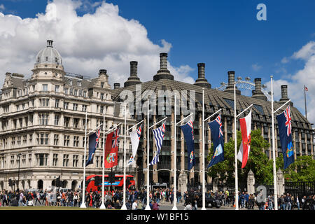 Commonwealth britannico bandiere in piazza del Parlamento giardino guardando verso edifici di Westminster Station su Bridge Street London Regno Unito Foto Stock