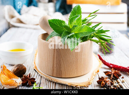 Erbe aromatiche. Fresco verde organico alle erbe aromatiche foglie in mortaio di legno Foto Stock