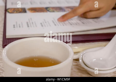 Movimento della donna che guarda all'interno del menu di un ristorante cinese Foto Stock