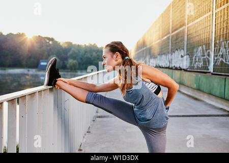 Femmina stretching runner durante la mattina allenamento Foto Stock