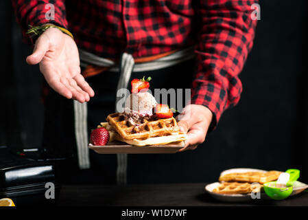 Lo chef serve freschi dessert waffle close up Foto Stock