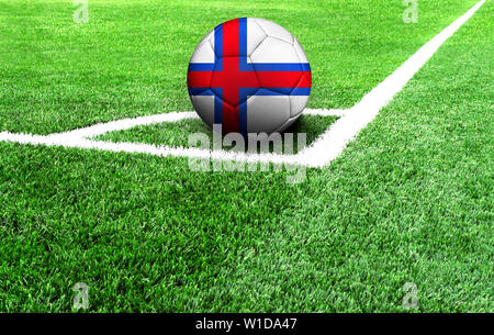 Pallone da calcio su un campo verde, bandiera delle isole Faerøer Foto Stock