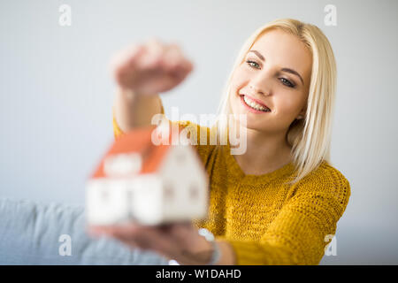 Felice giovane donna holding home figurina Home concetto di assicurazione. Foto Stock