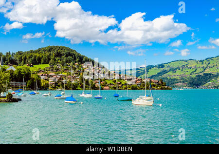 Thunersee (Thuner vedere), il lago di Thun con barche, barche a vela e le montagne delle Alpi . Vista dal villaggio nelle vicinanze Faulensee Spiez, Canton Berna, Svizzera. Foto Stock