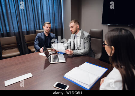 I colleghi incontro presso la sala conferenze per discutere di progetto in ufficio Foto Stock