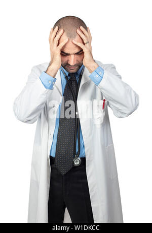 Desperate medico mantiene la testa tra le mani, indossa un mantello bianco. Concetto di stress sul posto di lavoro Foto Stock