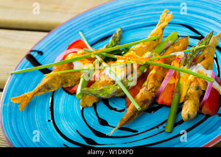 Alici fritte in pastella servito con salsa allo zenzero, pomodori, asparagi, cipolla e erba cipollina Foto Stock