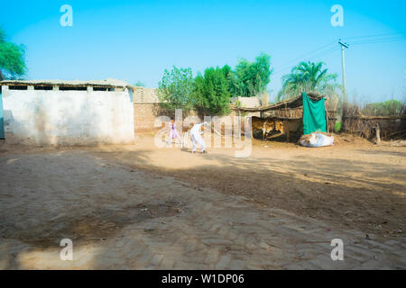 Rahimyar khan,punjab,pakistan-luglio 1,2019:alcuni ragazzi locali a giocare a cricket in un villaggio,battitore lasciando un bounser. Foto Stock