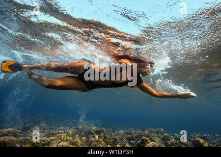 Attraente giovane donna galleggianti in splendido oceano Foto Stock
