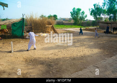 Rahimyar khan,punjab,pakistan-luglio 1,2019:alcuni ragazzi locali a giocare a cricket in un villaggio,battitore è bowlled. Foto Stock