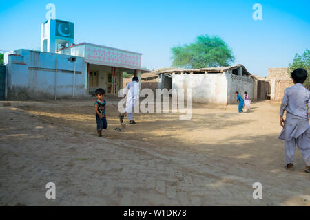 Rahimyar khan,punjab,pakistan-luglio 1,2019:alcuni ragazzi locali a giocare a cricket in un villaggio,battitore sta cercando di giocare un colpo. Foto Stock