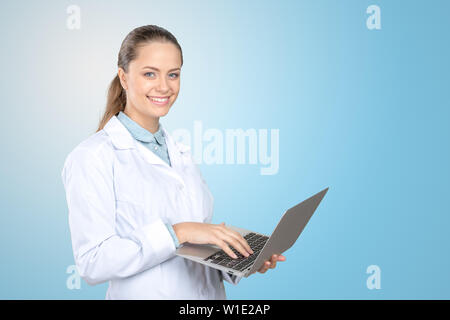 Attraente medico donna lavorando sul suo computer portatile Foto Stock
