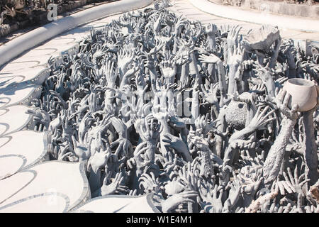 Chiang Rai, Thailandia - Novembre 2017: Centinaia di mani emergente dal terreno la scultura. Wat Rong Khun, Tempio bianco Foto Stock