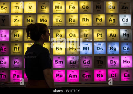 Royal Society Summer Science Exhibition, una giovane donna che guarda un illuminato Tabella Periodica celebra il centocinquantesimo anniversario, London, Regno Unito Foto Stock