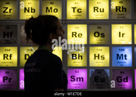 Royal Society Summer Science Exhibition, una giovane donna che guarda un illuminato Tabella Periodica celebra il centocinquantesimo anniversario, London, Regno Unito Foto Stock