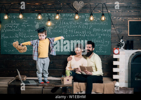 Concetto di supporto. Kid detiene orsacchiotto e di eseguire la. Ragazzo presentando la sua conoscenza a mamma e papà. I genitori in ascolto il loro figlio, lavagna su backgrou Foto Stock