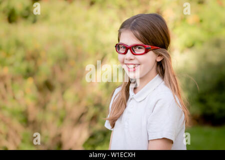 Ritratto di una ragazza bambino indossando rosso sport prescrizione di occhiali o occhiali di protezione Foto Stock