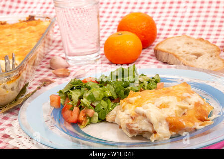 Baccalà con panna, un tradizionale piatto portoghese, con patate, cipolle, olio di oliva e ricoperto con formaggio parmigiano, cotta in forno. Foto Stock