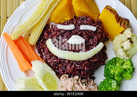 Riso marrone mangiare con il piccante insalata di tonno e verdure cibo pulito sul piatto Foto Stock
