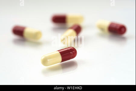 Penicillina anti-stress biotici capsule sversati attraverso una riflessione sullo sfondo bianco. Foto Stock