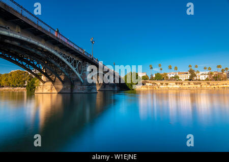Una lunga esposizione del Puente de Triana sul fiume Guadalquivir in Siviglia in background, Siviglia, in Andalusia, Spagna, Europa Foto Stock