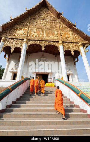 I monaci buddisti a salire le scale di un tempio di Pha That Luang, Vientiane, Laos, Indocina, Asia sud-orientale, Asia