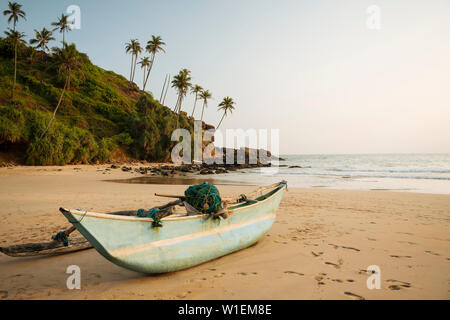 Barca di legno tradizionale Talalla sulla spiaggia al tramonto, South Coast, Sri Lanka, Asia Foto Stock