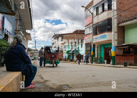 Chavín de Huantar, Ancash / Perù: 11 Giugno, 2016: vecchia donna guardando il ongoings sulla strada principale di Chavín de Huantar su un tipico occupato per i giorni feriali Foto Stock