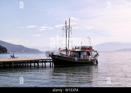 Imbarcazione turistica cruiser in piccola marina sul mare e una spiaggia bellissima, in attesa di turisti per nave a vela è al di fuori della porta per il prossimo tour turistici. Foto Stock