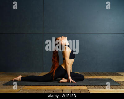 Foto di una giovane e bella donna fare yoga si allunga. Foto Stock