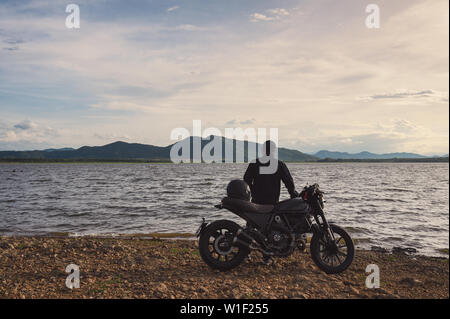 Giovane biker in piedi sul lato del big bike con visita al serbatoio naturale Foto Stock