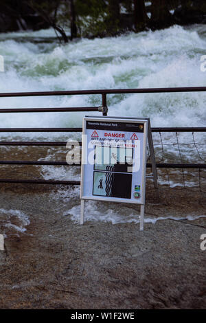 Cartello al confine del fiume Merced traboccato a Vernal Falls, avvertimento granito bagnato scivoloso nel Parco Nazionale di Yosemite, California, USA Foto Stock