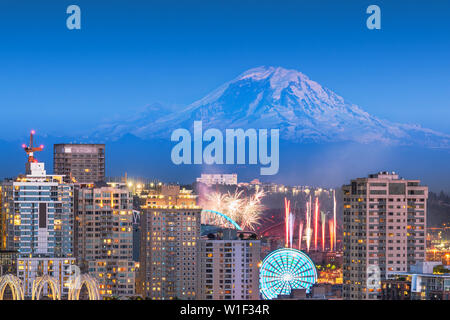 Seattle, Washington, Stati Uniti d'America skyline del centro con Mt. Rainier e uno spettacolo di fuochi d'artificio di seguito. Foto Stock