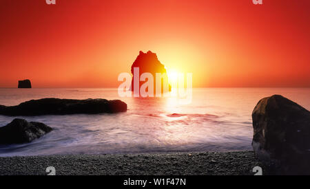 Tramonto su formazioni rocciose, spiaggia Reynisfjara, South Coast, Islanda Foto Stock