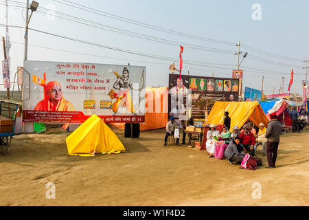 Pellegrini sotto giganteschi cartelloni, Allahabad Kumbh Mela, più grande del mondo di raccolta religiosa che, Uttar Pradesh, India Foto Stock