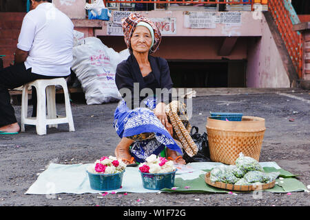 Vecchia donna che vendono fiori a Salatiga, Indonesia Foto Stock