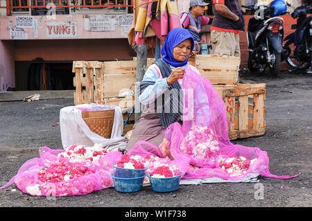 Vecchia donna che vendono fiori a Salatiga, Indonesia Foto Stock