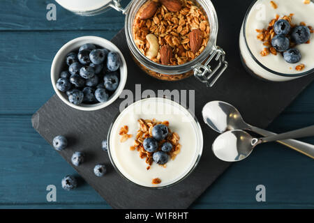 Composizione con dessert parfaits blu su sfondo di legno Foto Stock