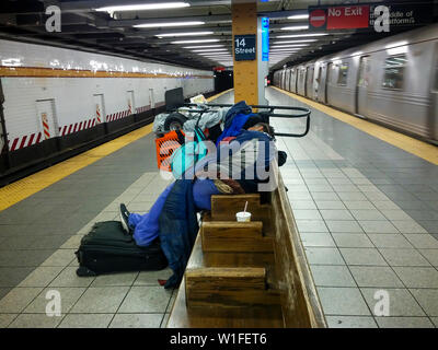 Una donna senzatetto con suoi possedimenti dorme su una panchina di una ottava avenue linea stazione della metropolitana di New York il Mercoledì, 26 giugno 2019. (© Richard B. Levine) Foto Stock