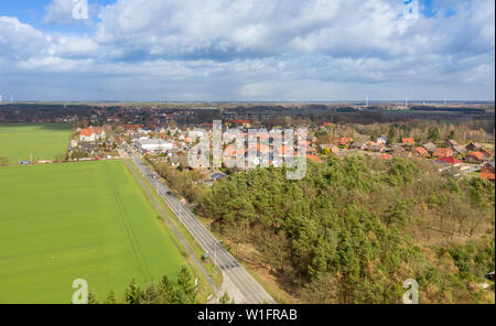 Vista aerea dell'entrata di un tedesco di piccola città con una strada di campagna tra campi e boschi per lo sviluppo del paese, drone volo Foto Stock