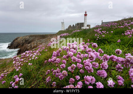 Il Lighthouse e abbey salire al di sopra del mare e coste rocciose a Pointe Saint-Mathieu in Bretagna, Francia Foto Stock